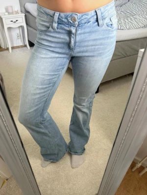 Ljusblå bootcut jeans - Säljer ett par jättefina ljusblå jeans från Gina Tricot. De har lagts upp hos skräddare eftersom de var väldigt utsvängda från början (se bild 7). De är fortfarande lite för långa på mig som är 171 cm. Materialet är stretchigt och väldigt bekvämt.  Det finns även en liten defekt (se bild 5), men den ser snarare ut som en snygg detalj och påverkar inte användningen.  Hör gärna av dig vid intresse! ❤️