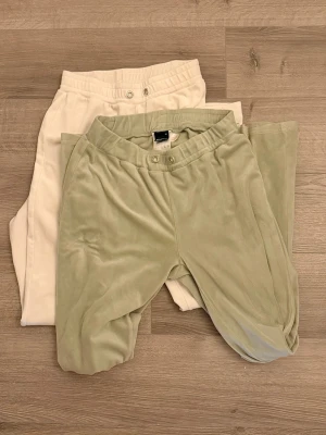 Två par mjukisbyxor paket bundle XS/S - Säljer två par mjukisbyxor i mjukt material, ett par i beige och ett par i ljusgrön. Båda har resår i midjan och knappdetaljer framtill. Perfekta för chill dagar eller när du vill vara extra bekväm. Vita byxorna är slim fit (passar bäst XS) och gröna är avslappnad (S)