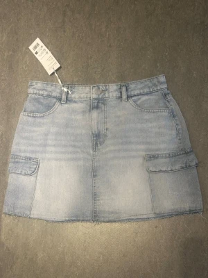 Jeans skirt - 💙 Ljus tvättad denim 💙 Trendiga cargofickor på sidorna 💙 Rå, fransad nederkant 💙 Aldrig använd – prislapp kvar  En stilren och trendig jeanskjol som är enkel att matcha med allt från linnen och t-shirts till stickade tröjor. Lätt att styla både till vardag och sommarens outfits. ☀️