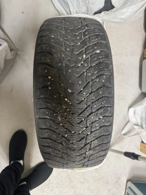 Svart vinterdäck från Nokian - Säljer ett svart vinterdäck från Nokian med tydligt mönster och grova spår för bra grepp på vintervägar. Däcket är tillverkat i slitstarkt gummi och har märkning på sidan. Perfekt för dig som behöver extra däck till bilen.