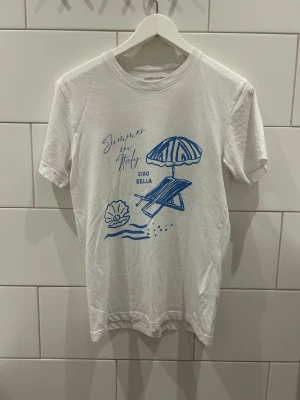 Vit t-shirt med tryck - Vit T-shirt med ett snyggt blått tryck Storlek: Xs Passform: Normal Skick: Bra skick Märke: Laidbclothing Skickas inom 24h