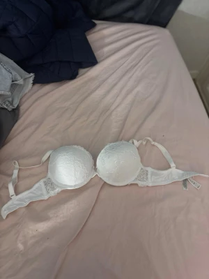 Vit vadderad push up bh från Lindex - Säljer en vit bh från Lindex i storlek 70B. Bh:n är vadderad med släta kupor och har tunna axelband. Liten spetsdetalj längs kanten för en söt touch. Passar perfekt under ljusa toppar.