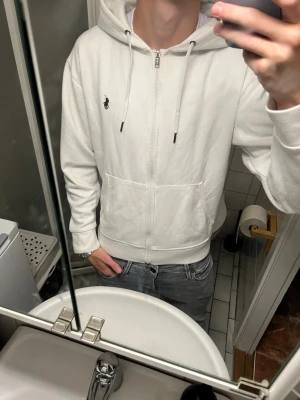 Ralph lauren hoodie - Säljer en clean vit Ralph lauren zip hoodie med mörkblå/svart häst i otroligt skönt material storlek Small men modellen är 177cm lång 