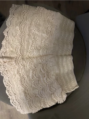 Spets shorts  - Säljer ett par vita shorts i vacker spets med detaljerat mönster. Shortsen har breda kanter och en mjuk, stretchig passform som känns både bekväm och snygg. Perfekta för dig som gillar romantisk och feminin stil.