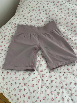 Träningsshorts - Träningsshorts ifrån nvgtn i en smutsrosa färg. Storlek S.