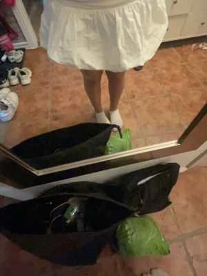 Vit kort ballongkjol med volym - Supersöt vit kortkjol med ballongformad siluett och bred midjeresår. Kjolen har en luftig och voluminös look som ger en trendig vibe. Perfekt att styla med crop tops eller hoodies för en cool outfit.