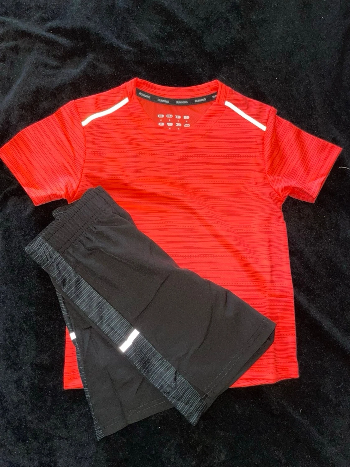 Röd tränings-tshirt och svarta shorts