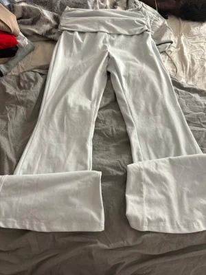 Vita utsvängda leggings - Snygga vita leggings med utsvängda ben och bred linning i midjan. Tillverkade i ett stretchigt och mjukt material som sitter bekvämt. Perfekta för dig som gillar en trendig och avslappnad stil.