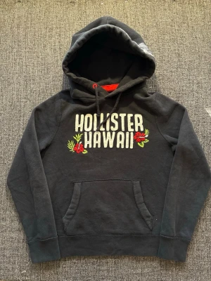 Hollister hoodie ~ hawaii edition - Sjukt eftertraktad Hollister hoodie ~ vintage modell som inte längre produceras | st M | färg svart | klassisk passform | liten defekt som knappt syns och inte påverkar användningen | perfekt vintage piece | OBS kan gå ner lite i pris vid snabb affär! 🏄
