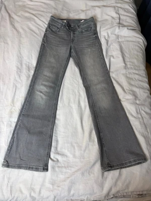 Grå bootcut jeans med utsvängda ben - Snygga grå jeans med bootcut-modell och utsvängda ben. Klassisk femficksdesign och normal midja. Jeansen har en tvättad look och är tillverkade i ett mjukt denimtyg som ger en avslappnad vibe.