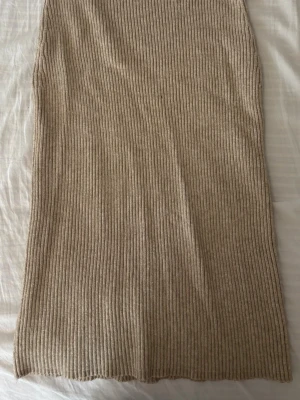 Beige ribbad långkjol från Vila - Säljer en beige ribbad långkjol från Vila i storlek XS. Kjolen har en mjuk och stretchig känsla. 