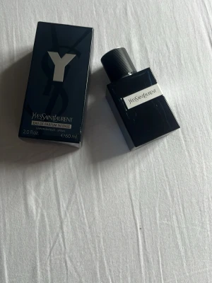 Yves Saint Laurent Y EdP Intense 60ml - Yves Saint Laurent Y Eau de Parfum Intense är en parfym i en elegant, mörkblå glasflaska med svart lock. Flaskan har en stilren, fyrkantig form och en tydlig Y-logga på förpackningen. Doften är intensiv och modern, perfekt för dig som gillar exklusiva parfymer.