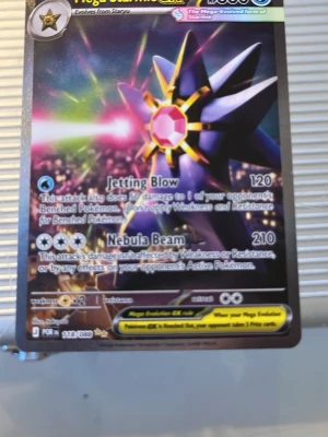 Pokémonkort Mega Starmie EX - Säljer ett Pokémonkort av typen Mega Starmie EX med holografisk yta. Kortet har färgstark design med lila, gult och rosa motiv och coola attacker som Jetting Blow och Nebula Beam. Perfekt för samlare eller dig som vill boosta din lek med en mäktig vatten-Pokémon. Bra skick helt ny
