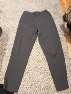 Mörkgrå kostymbyxor Selected Homme - Säljer ett par mörkgrå kostymbyxor med rak passform och klassisk design. Byxorna har knapp och gylf fram samt två bakfickor med knappar. Perfekta till en stilren look. Materialet känns mjukt och lätt, bomull eller polyester. Nypris runt 700. W 29 L 32