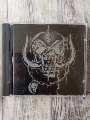 Motörhead No Remorse CD - Säljer en CD med Motörheads samlingsalbum 'No Remorse'. Omslaget har det klassiska Snaggletooth-motivet i svart och silver. Skivan innehåller låtar som Ace of Spades, Overkill och Bomber. Perfekt för dig som gillar hårdrock och samlar på klassiska album.