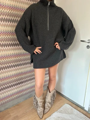 Stickad soft goat tröja! - Soft goat tröja som går att ha på många olika sätt! ALDRIG ANVÄND LAPPEN KVAR! Säljer en mörkgrå oversized stickad tröja med hög krage och halv dragkedja framtill. Tröjan har grov ribbstickning, långa ärmar och en avslappnad passform. Perfekt för lager på lager och en cool, avslappnad stil.