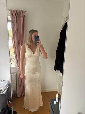 Balklänning/maxiklänning Nelly  - Säljer denna superfina cremevita/champagnefärgade balklänningen från Nelly som är slutsåld. Lappen finns kvar och den är endast testad! Nypris 799kr.