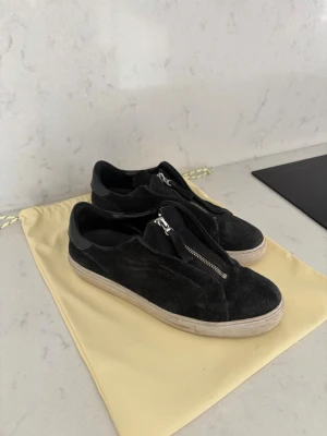 Axel Arigato svarta mockasneakers - Snygga svarta sneakers från Axel Arigato i mocka. Lite slitna,