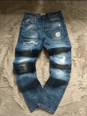 Archive jeans  - Säljer ett par riktigt snygga archive jeans med fina slitningar och handwashed! Pris går alltid att diskutera vid snabb affär!  Mått: Midjemått: 38cm Längdmått: 103cm Benöppning: 16cm