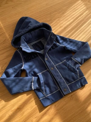 Hollister Cardigan Sällsynt  - Säljer en riktig snygg Hollister cardigan, väldigt sällsynt. Storleken är S. Skicket är topp 10/10. Priset kommer ligga på 799kr, kan sänkas.