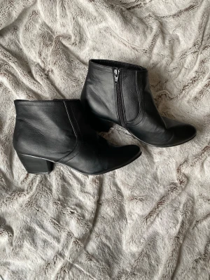 Klackade boots äkta läder - Svarta boots med klack i äkta läder och dragkedja innersida, storlek 40 Är använda så finns visst slitage, det mesta syns på bilderna.  5cm klack  Vet ej vilket märke, signerad med ”style inc”  Dragkedjorna funkar utan problem🌸
