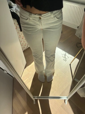 Vita bootcut jeans från Cheap Monday - Säljer ett par vita bootcut jeans från Cheap Monday med klassisk femficksmodell och logga bak på linningen. Jeansen har hög midja och är tillverkade i ett stretchigt denimtyg som sitter snyggt. Perfekta för dig som vill ha en clean och fräsch look.