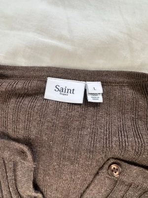 Brun ribbad kofta från Åhléns  - En väldigt Snygg brun ribbad kofta från Åhléns, köpt för ca 6 månader sedan. Koftan är som ny, använt ett fåtal gånger.