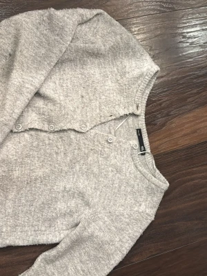 Ljusgrå kofta från Lager 157 -  Ljusgrå kofta från lager 157 med knappar framtill. Koftan är stickad med ett mjukt material och har långa ärmar. Perfekt att slänga över en t-shirt eller linne. Pris går att diskuteras