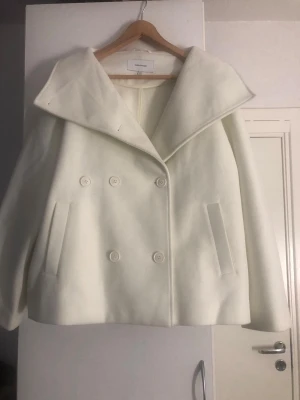 Crémevit kappa från Bubbleroom i storlek XL/42 - Crémevit skepparkappa från BUBBLEROOM i storlek XL/42. Jackan har aldrig varit använd eftersom den inte passade. Perfekt inför våren och hösten! 