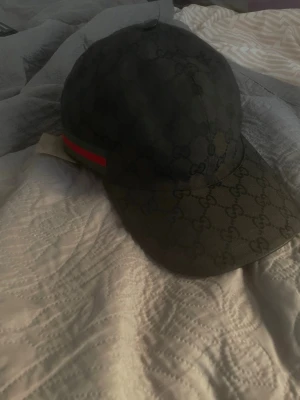 Gucci keps - Äkta Gucci Keps. Svart baseball original gucci keps i storlek S (56 Cm) knappt använd ligger bara och gör ingen nytta. Tyvärr inga tillbehör med. Men dem som kan gucci vet att denna är äkta..