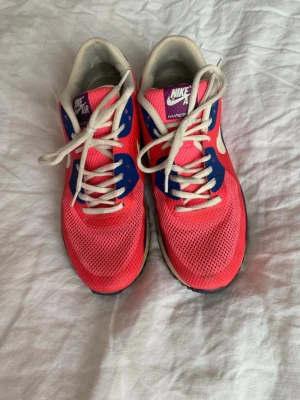 Nike Air Max Hyperfuse rosa/blå - Nike Air Max Hyperfuse sneakers i en mix av rosa, blått och vitt med lila detaljer. Skorna har meshmaterial för bra ventilation, vita snören och den klassiska Air Max-sulan med synlig luftdämpning. Swoosh-logga på sidan och Nike Air-märke på plösen.