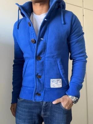 Vintage Hollister Hoodiejacka  - Säljer denna feta Hollister hoodiejackan, fodrad inne så varm och skön till det kalla vädret | Väldigt bra skick förutom lite tecken på användning se sista bild | Storlek S | Längd ≈ 65cm, Bredd armhåla - armhåla ≈ 52cm | Modell 175cm, 68kg