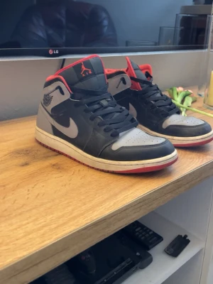 Nike Air Jordan 1 svart/röd/grå - Säljer mina Jordans då jag aldrig använder dom längre. Dom är i helt okej skick men funkar fortfarande att använda, dom är väldigt bekväma. Det går o sätta häl skydd där det är sönder. Box ingår och tvättar dom. Pris kan diskuteras om det är bra.
