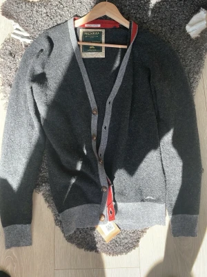 McNeal Cardigan - Riktigt snygg och unik mörkgrå kofta från McNeal med ljusgrå kanter och bruna knappar. Säljer pga att den tyvärr är lite liten för mig. Storlek S