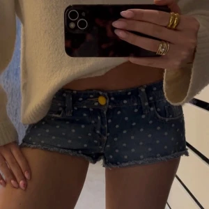 Blå prickiga lågmidjade jeansshorts - Säljer ett par blå lågmidjade jeansshorts med vita prickar, har sett dessa överallt på Pinterest. Midje måttet är ca 38cm tvärsöver och ca 68cm runt❣️❣️