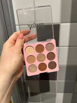 Joyful ögonskuggspalett Makeup Mekka - Endast testad 1 gång vissa av färgern. Joyful ögonskuggspalett från Makeup Mekka med nio nyanser i bruna, beige och guldiga toner. Paletten har både matta och skimrande skuggor i en fyrkantig rosa plastförpackning med genomskinligt lock.