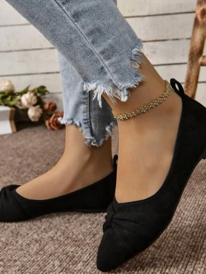 Svarta ballerinaskor med rosett - Stilrena svarta ballerinaskor med spetsig tå och dekorativ rosett framtill. Skorna har en klassisk design och är tillverkade i ett mockaliknande material. Perfekta för dig som vill ha en enkel men trendig look. Aldrig använt fick dem som present för ett tag sedan 38 i storlek 