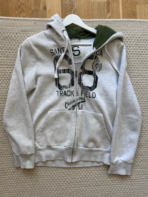 Ljusgrå hoodie med zip - Hej och välkommen till liljestrands nu säljer vi en hoodie med zip han på bilden är 170 och väger 50kg kom med bud osv mvh Liljestrand