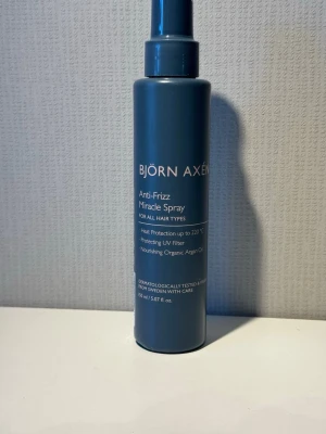 Björn Axén Anti-Frizz Miracle Spray - Anti-Frizz Miracle Spray från Björn Axén för alla hårtyper. Ger värmeskydd upp till 220°C, UV-filter och innehåller närande ekologisk arganolja. Kommer i en stilren mörkblå plastflaska med spraymunstycke. Innehåll: 150 ml.