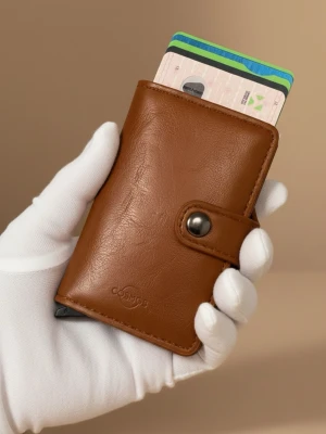 Helt NY. 🇸🇪Svensk märke. Brun korthållarplånbok i läder - 🇸🇪Svensk märke. Snygg brun plånbok från Cosmos i riktigt strak PU läder med smart knappstängning. Plånboken har inbyggd korthållare i metall som enkelt skjuter ut korten. Perfekt för dig som vill ha stilren och kompakt förvaring av kort.