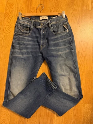 Replay anbass hyperflex  32/32  - Snygga blå jeans från Replay med klassisk femficksdesign och coola slitningar på låren. Jeansen är slim och är tillverkade i bomull med en stretch för extra komfort därav hyperflex modellen.  Finns fortfarande ute i butiker men bytt stil därav säljes. 