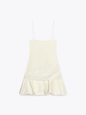 Vit kort klänning med volang - Söt vit kort klänning med smala axelband och volang nertill. Klänningen har en enkel, rak passform och är tillverkad i ett lätt, slätt material som ger en luftig känsla. Perfekt för varma dagar och somriga tillfällen.