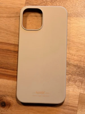 Beige mobilskal från Holdit - Snyggt och stilrent beige mobilskal från Holdit. Skalets yta är matt och mjuk, tillverkat i silikon som ger ett bra grepp och skydd för mobilen. Passar perfekt för dig som vill ha ett minimalistiskt och modernt utseende på din telefon.