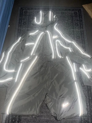 Nike reflekterande tracksuit set - Säljer ett grått tracksuit set från Nike med reflekterande detaljer över hela jackan och byxorna. Setet har huva, dragkedja och dragsko i midjan. Perfekt för löpning eller streetwear när du vill synas i mörkret.
