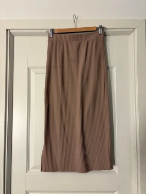 Beige medellång kjol - En beige medellång kjol med slits på ena sidan, bara använd ett par gånger så nästan helt ny