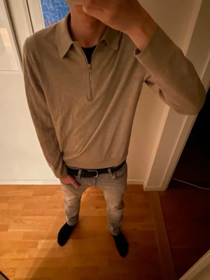 Beige tröja med halv dragkedja - Snygg beige långärmad tröja med krage och halv dragkedja framtill. Tröjan har en stilren och enkel design, perfekt att matcha med jeans eller chinos. Materialet är mjukt och bekvämt.       Hör gärna av dig för fler frågor.