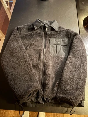 Svart teddyjacka från Levi's - En stilren svart Levi's flis jacka perfekt för våren. Helt oanvänd med etikett kvar. Bara och höra av sig om det är frågor.