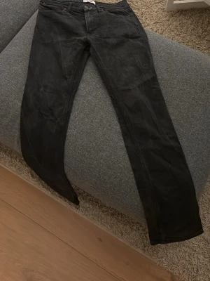 Svarta raka jeans från Acne - Säljer ett par svarta jeans från Acne med klassisk femficksmodell och raka ben. Jeansen har normal midja och är tillverkade i ett slitstarkt denimtyg. Perfekta för dig som gillar en clean och stilren look.
