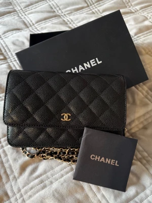 Handväska  - Svart handväska med guldiga detaljer. 