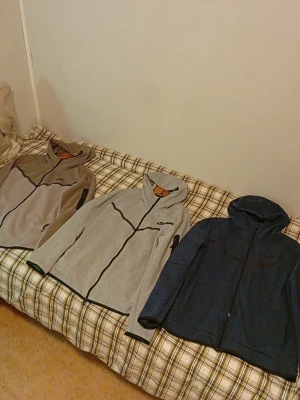 Nike Tech Fleece hoodies  - Du kan köpa dom styckvis, 400kr styck. Nike Tech Fleece hoodies i 3 olika färger, En Navy/Mörkblå, en Hel Grå och en Som är Grå/Beige. och dragkedja. Huva, två fickor fram och en extra ficka med dragkedja på ärmen. Perfekt för en sportig och avslappnad stil.